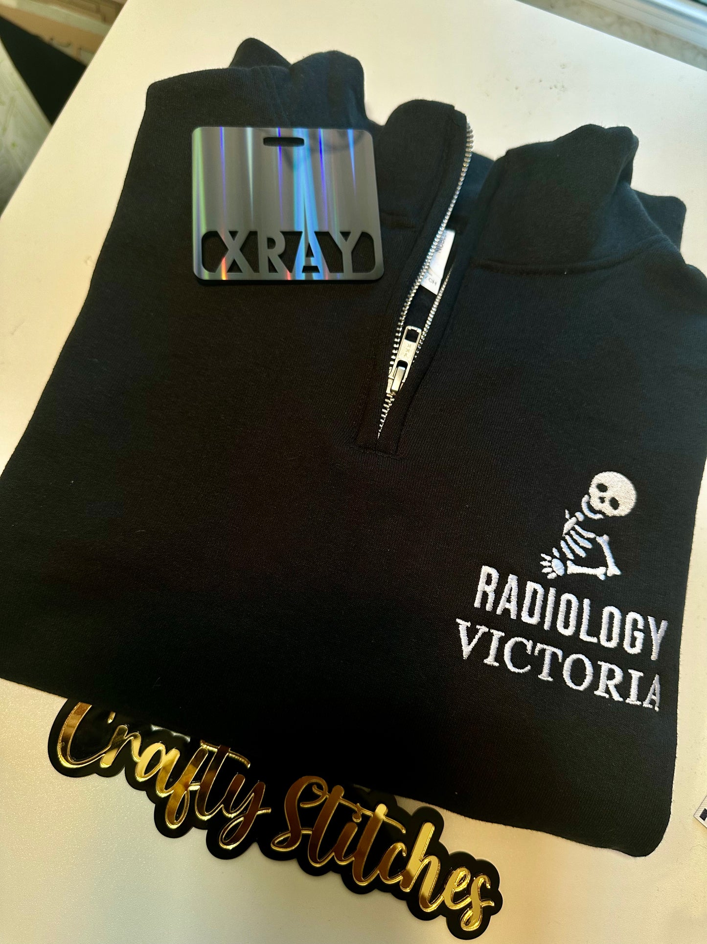 Black zip-up hoodie with 'Radiology Victoria' logo on a white surface, featuring a 'X-Ray' tag.